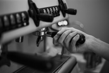 Barista holds a holder and makes coffee with a double-boiler coffee machine