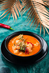 Traditional Thai soup Tom Yum kung with seafood, coconut milk and chili pepper