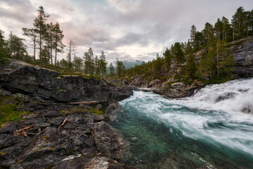 Venue Asbjorn fosse, Norwegian landscape, a view of the mountains, a mountain stream flows below, and the mountain slopes are covered with grass and shrubs	