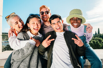 Multiracial group of friends smiling posing in front of the camera for a picture.