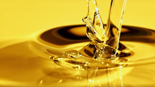 Olive oil pours in a stream with splashes. Macro background. Filmed on a high-speed camera at 1000 fps. 