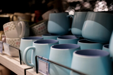 Colorful ceramic mugs on display at a department store. Home decor and comfort concept