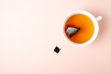 a cup of citrus tea with a tea bag floating in it, top view, copy space