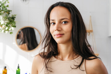 Close up beauty portrait of mixed-race woman in bathroom. Confident young woman feeling positive and comfortable in her body. Wellness and body positivity