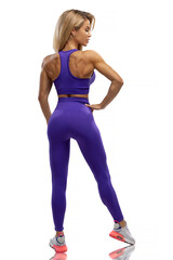 Blonde fit girl in blue leggings and top on a white background in the studio