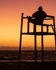 Hombre apreciando el atardecer sentado 