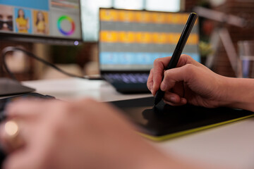 Retouching artist using stylus on graphic tablet to edit photo, creating professional photography...