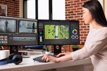 Foto op Plexiglas Asian graphic editor working on editing video and audio footage with professional software to create film content for post production. Using movie montage to edit multimedia movie. © DC Studio