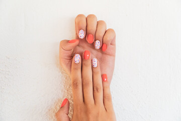 Nail art. Nail art on woman hands with orange color and orange patterns. Manicure concept. Selective focus included.