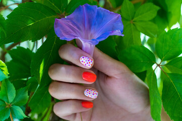Nail art. Nail art on woman hands with orange color and orange patterns. Manicure concept. Selective focus included.