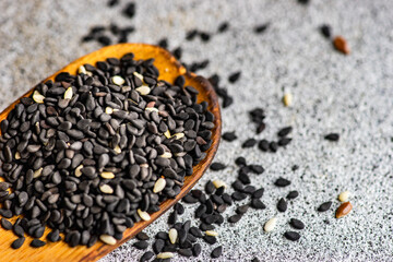 Fototapeta na wymiar Black sesame seeds in the wooden spoon