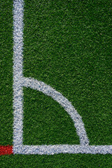 Closeup of artificial grass turf on a recreational sports field, with white stripes, as a graphic background
