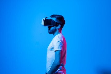 Bearded young man wearing virtual reality goggles and interacting with a virtual environment....