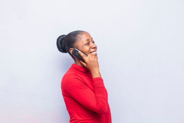 beautiful African girl smiling making voice call looking cheerful, phone on ear-concept