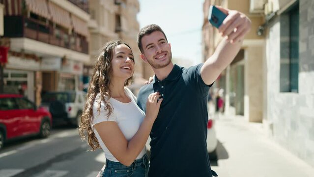 Young hispanic couple smiling confident make selfie by the smartphone at street