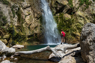 Female Hiker with Red Backpack under Beautiful Gregorcicev Waterfall in Slovene Julian Alps