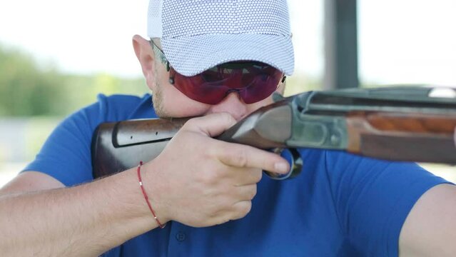 Sportsman shoots from a double-barreled shotgun, A sports field for a shooting test is shooting at flying skeet
