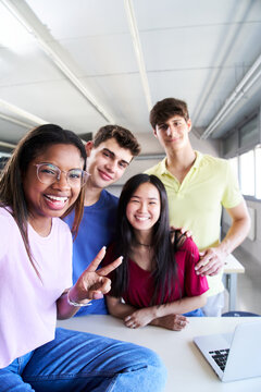 Vertical Selfie Portrait of a group of students in class looking at the camera. Young people of different ethnicities posing for a photo in the classroom. Back to school.