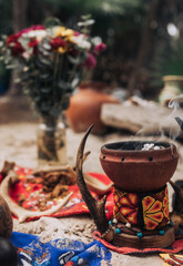 Incense burner smoking with flowers in the background in Tulum