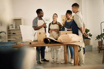 Group of designers doing design teamwork while talking and working on a creative project. A team of diverse fashion studio workers brainstorming. Young staff work together on making clothes