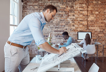 Architect, design engineer or building contractor drawing a plan on a drafting table for a project or development in his office. A male designer doing a blueprint sketch at an architecture company - obrazy, fototapety, plakaty