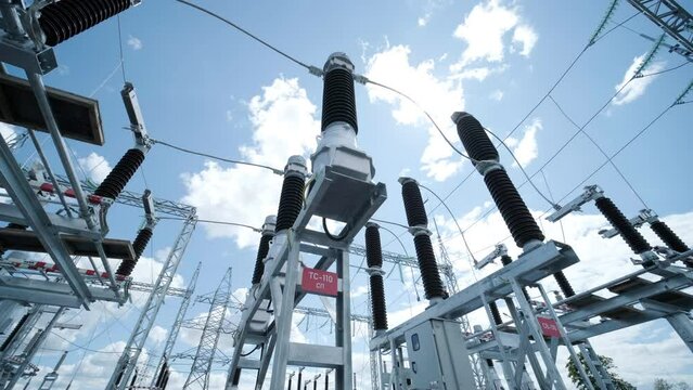Many high voltage electrical insulators in power substation against blue sky background