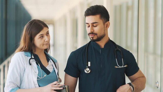 a doctor gives a bribe to a nurse in a hospital corridor