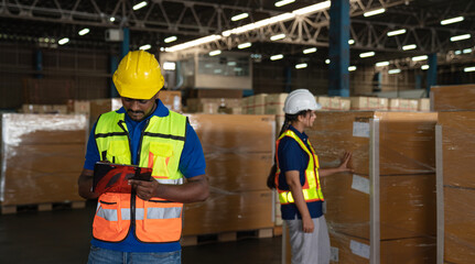 Portrait of staff worker standing in warehouse with his arm crossed looking at camera.