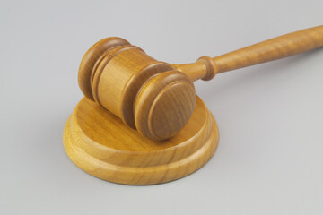 Wooden judge gavel on gray background close up. Laws, justice, court and legal system concept.