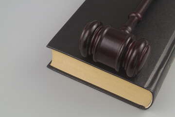 Wooden judge gavel on legal book on gray background 