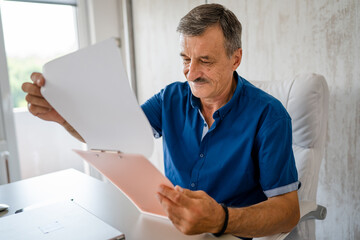 Fototapeta premium senior caucasian man working at the desk table at the office or home