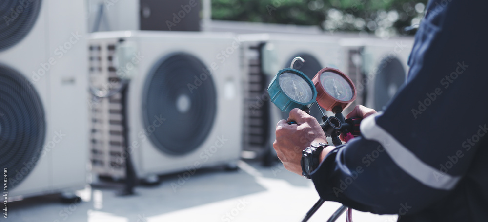 Wall mural technician is checking air conditioner ,measuring equipment for filling air conditioners.