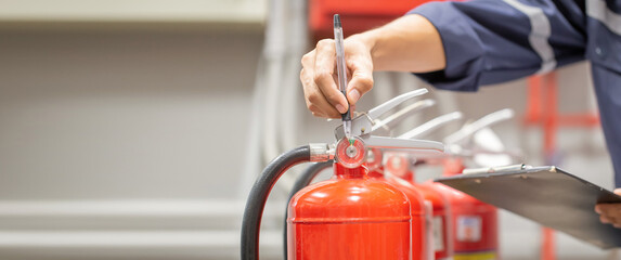 Engineer are checking and inspection a fire extinguishers tank in the fire control room for safety...