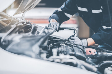 Mechanic works on the engine of the car in the garage. Repair se