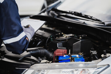 Professional mechanic working on the engine of the car in the garage. Car repair service.
