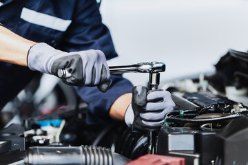 Professional mechanic working on the engine of the car in the garage. Car repair service.