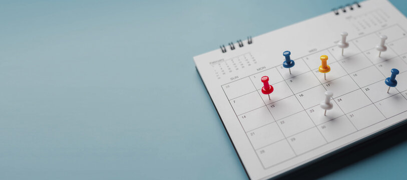 Embroidered red pins on a calendar event Planner calendar,clock to set timetable organize schedule,planning for business meeting or travel planning concept.