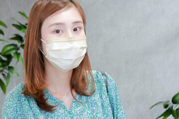	マスク姿の若い女性｜背景グレー