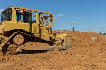 While doing landscaping work on a construction site, bulldozer works with soil from the earth bulldozer leveling ground