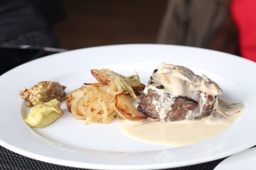 Close up of a delicious Steak Diane served with potatoes and onion on a plate, Soft Focus