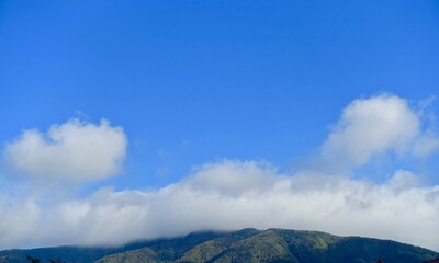 雲に覆われた緑の山と青空