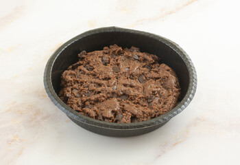 Raw chocolate chunk brownie cookie mix dough  in paper baking pan