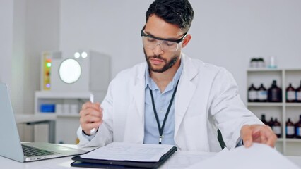 Scientist writing a science report to document new information in the lab at work. Close up of a young and serious professional researcher browsing online and noting the new scientific data findings