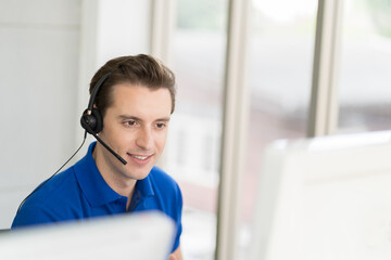 Male call center with headset service support customer by computer. Technical support operator...