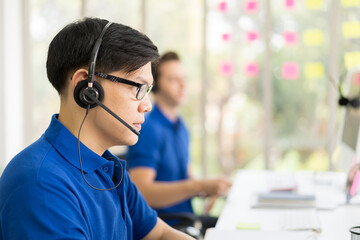 Team of customer service call center with headset working with computer. Group of technical support...
