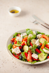 Greek salad of fresh cucumber, tomato, sweet pepper, lettuce, red onion, feta cheese and olives with olive oil. Healthy food