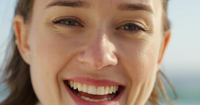 Happy, carefree and smiling woman having fun and feeling relaxed outside in summer. Closeup portrait of the face of a young, joyful and beautiful female laughing and relaxing outdoors during the day