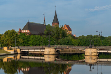 Fototapeta premium View of the Koningberg Cathedral on Immanuel Kant Island against the background of the bridge over the Pregolya River on a sunny summer day, Kaliningrad, Russia