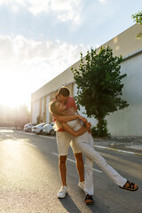 Couple has fun and laughs. Young hipster couple hugging each other in city. Summer love story, beautiful stylish young couple. Spring fashion urban concept with boyfriend and girlfriend. Select focus