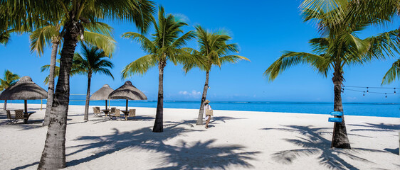 Le Morne beach Mauritius Tropical beach with palm trees and white sand blue ocean and beach beds...